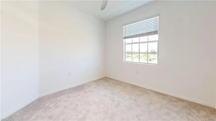 Unfurnished room featuring light carpet and ceiling fan