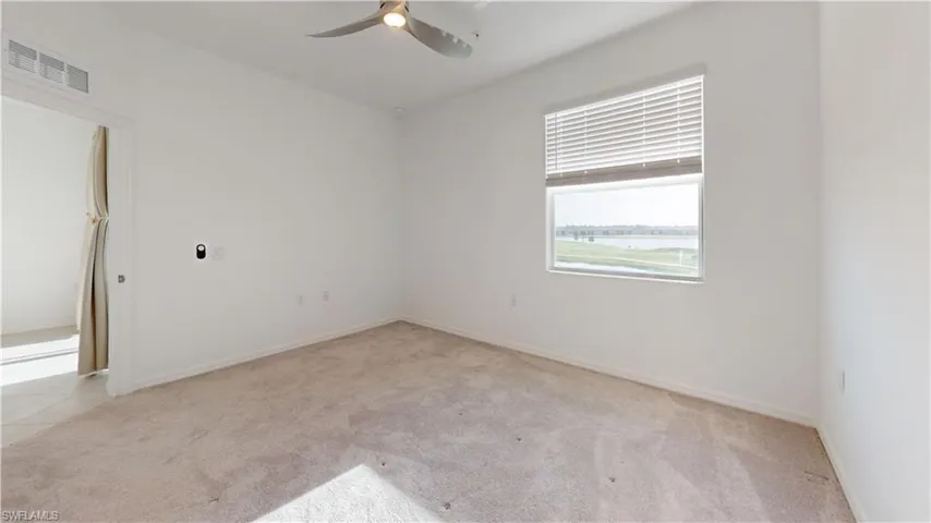 Spare room featuring light carpet and ceiling fan