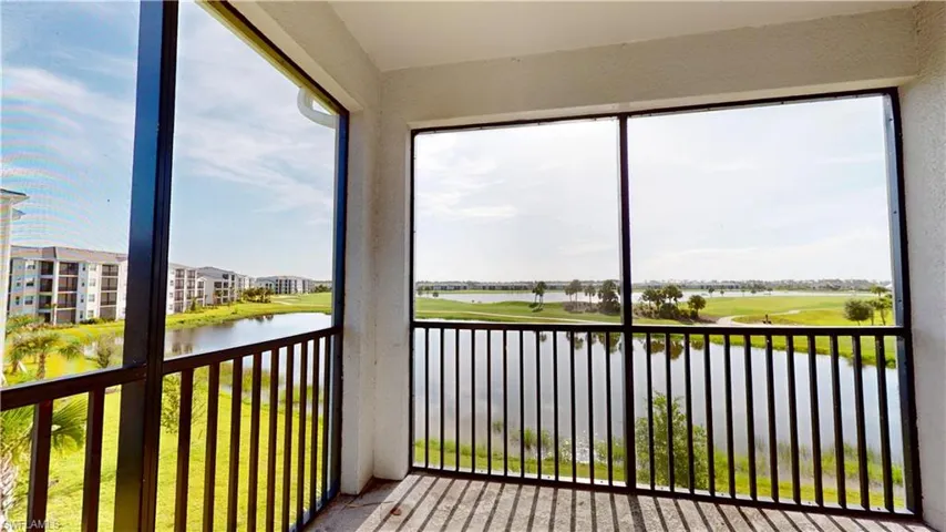 Unfurnished sunroom with a water view and view of golf course