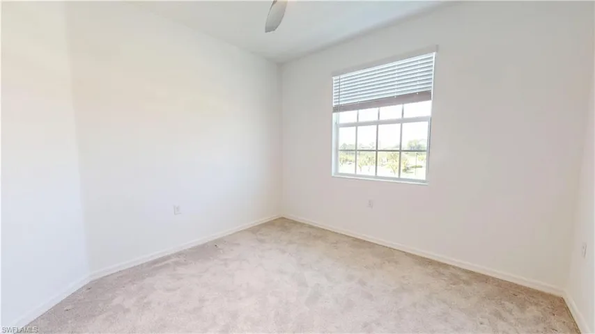 Unfurnished room featuring light carpet and ceiling fan