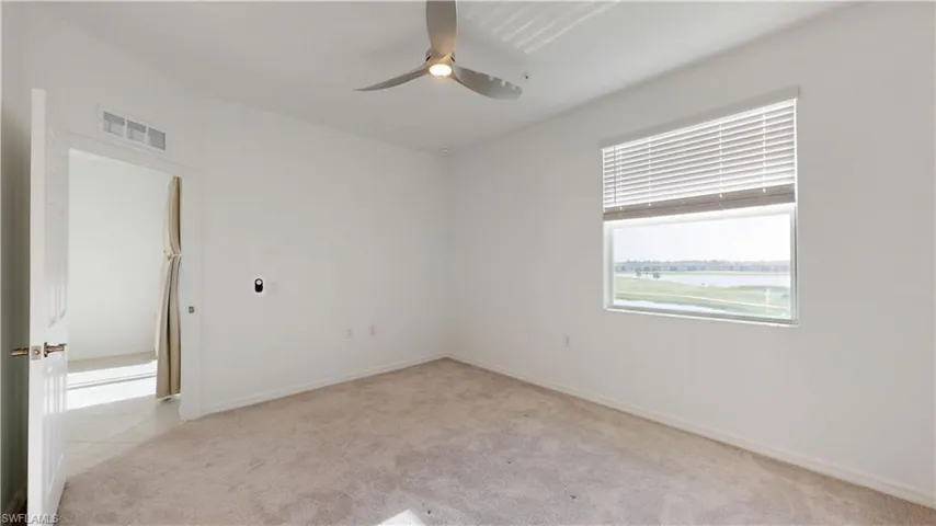 Spare room featuring light carpet and a ceiling fan
