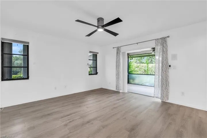 Spare room with light hardwood / wood-style floors, a wealth of natural light, and ceiling fan