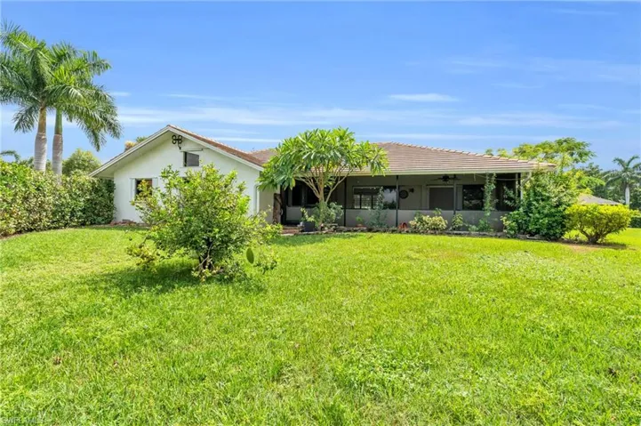 Back of property featuring a yard