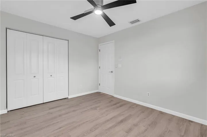 Unfurnished bedroom featuring light wood-type flooring, ceiling fan, and a closet