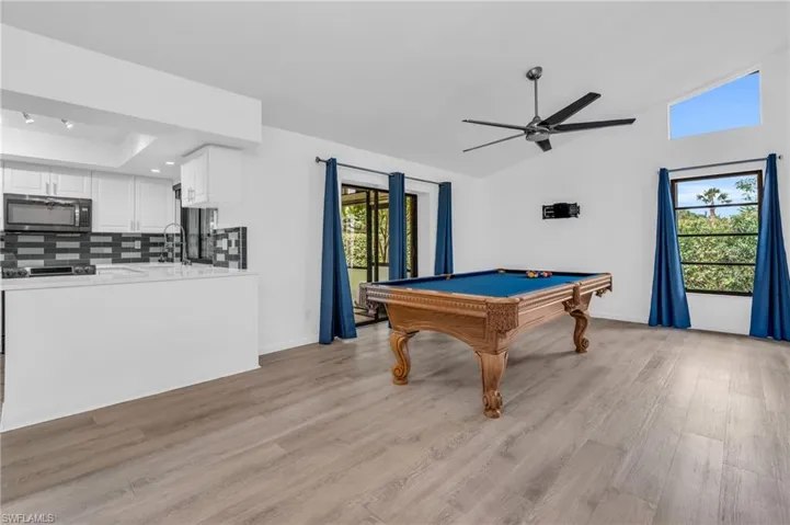 Playroom featuring a wealth of natural light, billiards, light hardwood / wood-style floors, and ceiling fan
