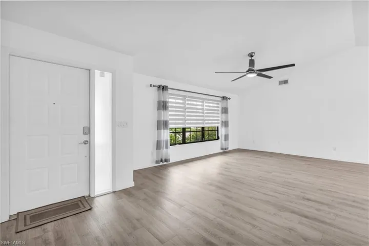Foyer entrance featuring ceiling fan, light hardwood / wood-style flooring, and vaulted ceiling