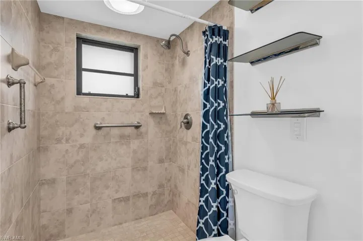 Bathroom with a shower with curtain and toilet