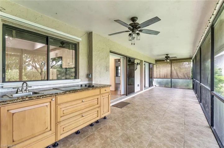 Unfurnished sunroom with ceiling fan, a wealth of natural light, and sink
