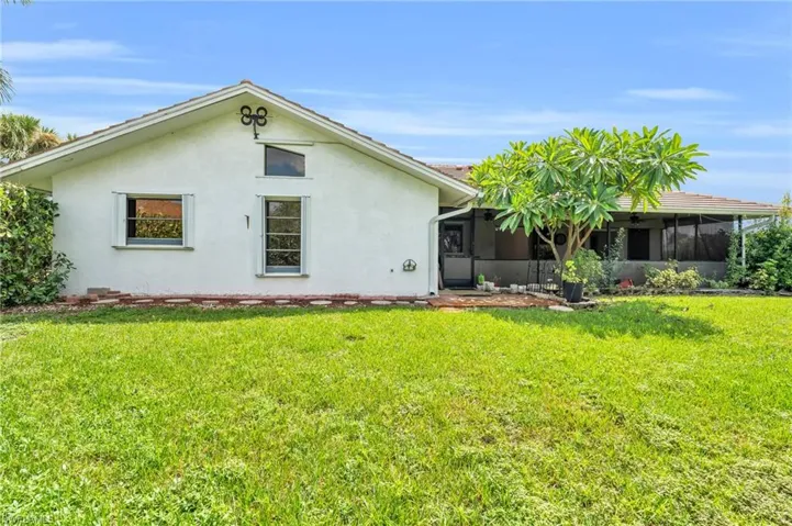Back of property with a yard and a sunroom