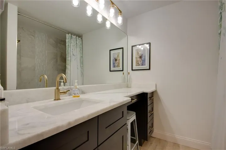 Bathroom with vanity, a shower with curtain, and wood-type flooring