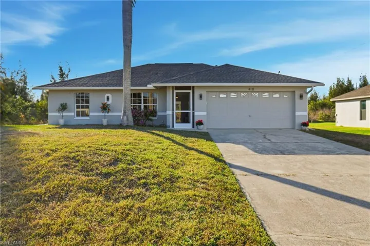Ranch-style house with stucco siding, a front lawn, concrete driveway, and an attached garage