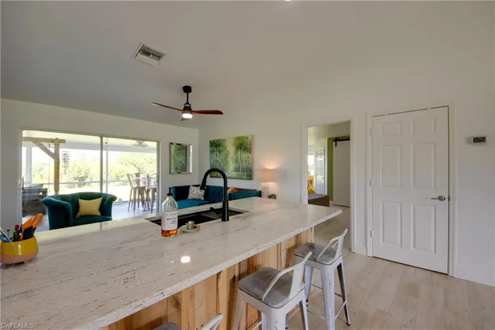 Kitchen peninsula with light granite countertops, new sink & faucet, and ceiling fan