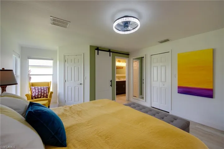 Bedroom featuring a barn door to bathroom
