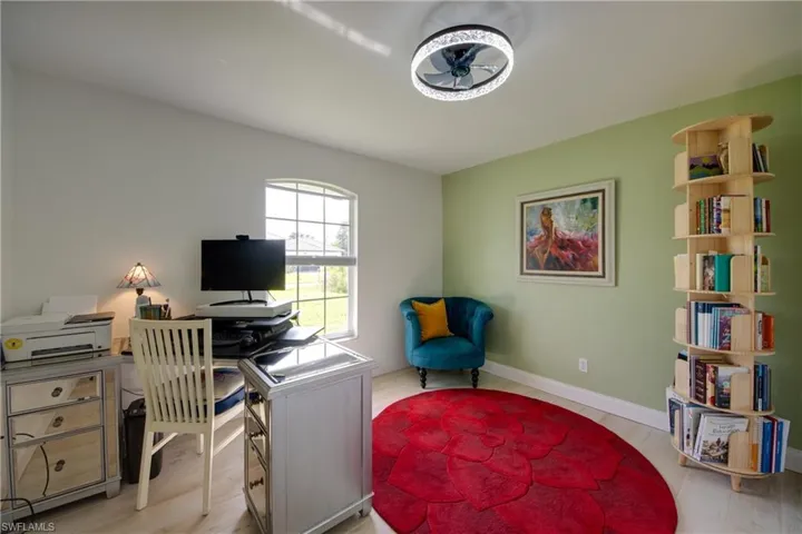 Office/guest room with ceiling fan and plank tile flooring