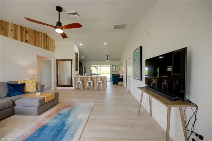 Entry way featuring high vaulted ceiling, ceiling fan open to kitchen