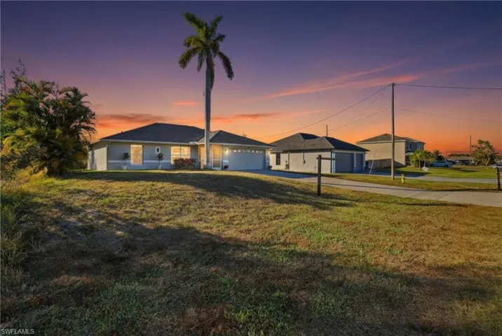 Ranch-style home with concrete driveway, a front yard, and a garage