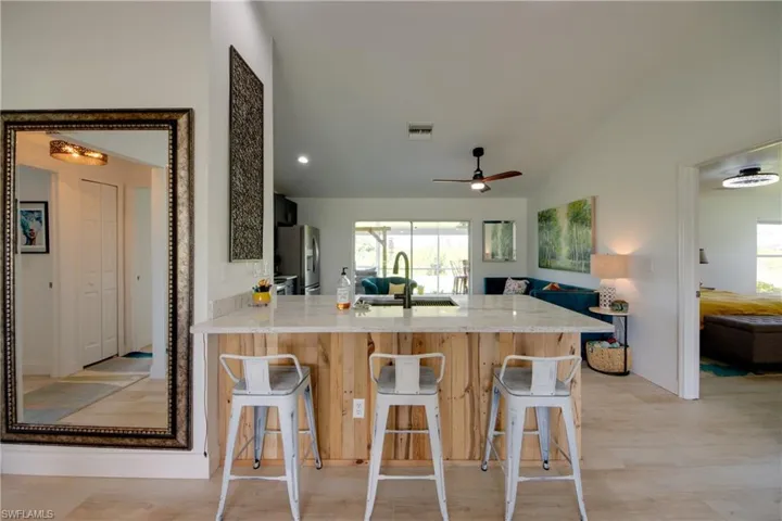 Kitchen with stainless steel fridge with ice dispenser, kitchen peninsula, sink,  and ceiling fan