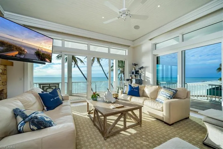 Living Room featuring wooden ceiling, ceiling fan, and a beach view