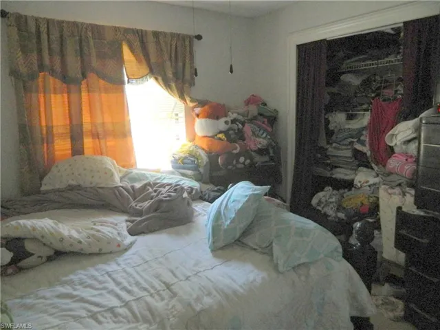 Bedroom featuring a single window and an open-entry closet with built-in wire shelving