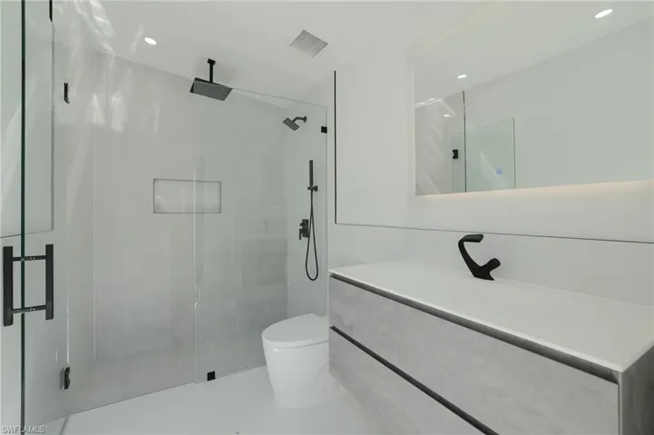Full bathroom featuring vanity, a stall shower, and recessed lighting