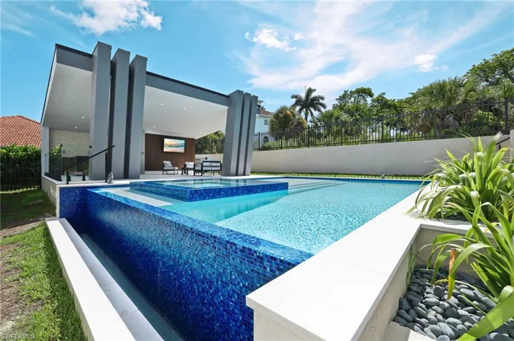 View of swimming pool featuring a patio area and a pool with connected hot tub