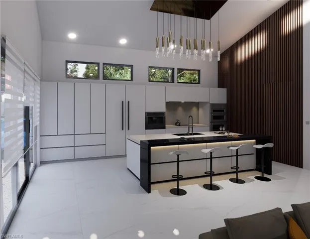Kitchen with modern cabinets, a high ceiling, double oven, light marble finish flooring, and a sink
