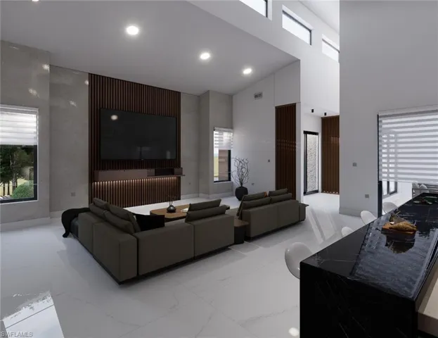 Living area featuring light marble finish flooring, a high ceiling, healthy amount of natural light, and recessed lighting