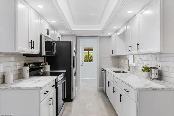 There is a Custom Tray Ceiling with LED Accent Lighting & Quartzite Counters & New S/S Appliances