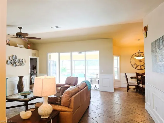 Tiled flooring throughout, ceiling fan, white paneled wainscoting, sliding glass doors, and recessed lighting