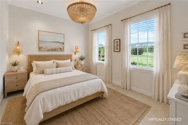 Recessed lighting, crown molding, two large windows, wood-finish bed frame, and a beaded chandelier
