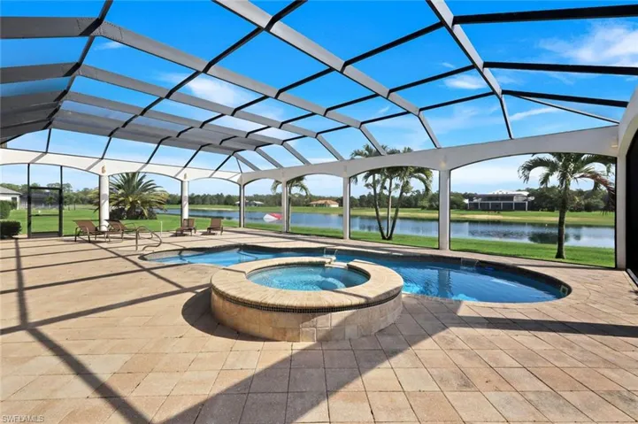 Screened pool enclosure with a custom-shaped swimming pool and integrated spa