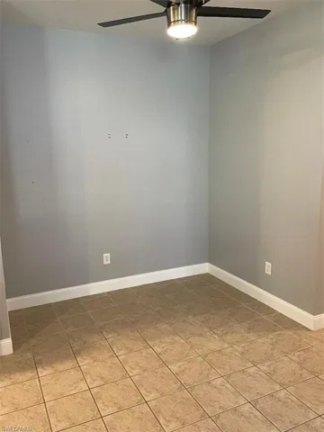 Eat in kitchen with light tile patterned floors and ceiling fan