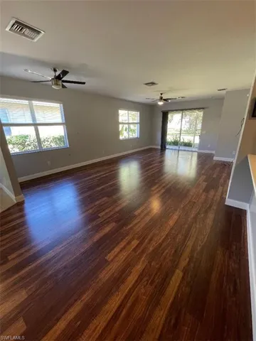 Living room with flooring / wood-style flooring, ceiling fan, and plenty of natural light