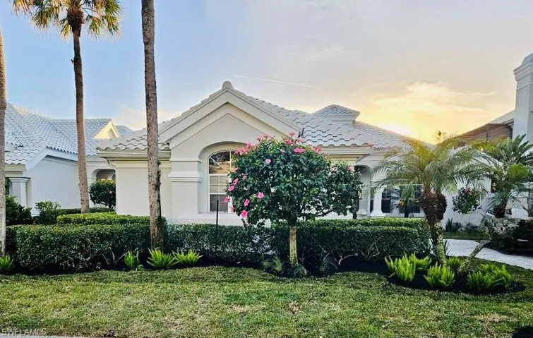 Mediterranean / spanish-style home featuring a lawn, a tile roof, and stucco siding