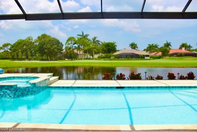 View of pool with a water view, a pool with connected hot tub, and a lanai