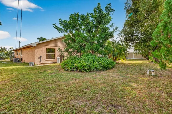 Back of house featuring a yard and stucco siding