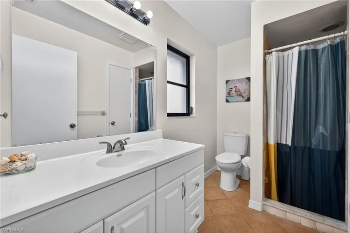 Bathroom featuring a shower stall, vanity, and light tile patterned floors