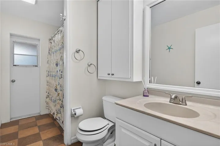 Bathroom featuring a shower with shower curtain, vanity, and dark floors