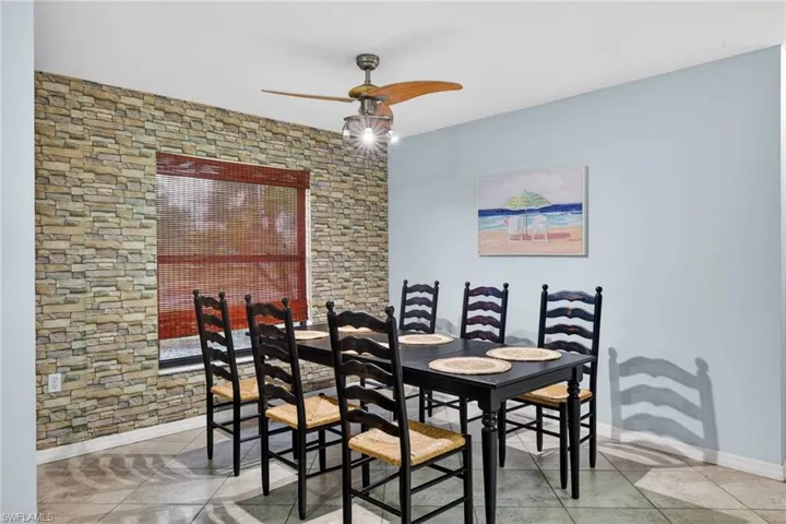 Dining space with ceiling fan and light tile patterned floors