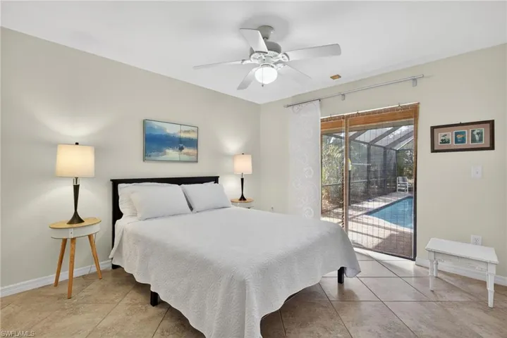 Bedroom featuring access to pool deck, ceiling fan, and a sunroom