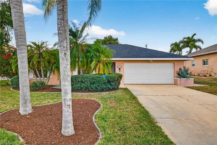 View of front of home featuring concrete driveway, stucco siding, roof with shingles, an attached garage, and a front yard
