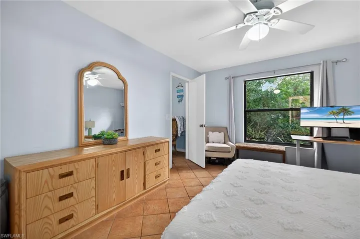 Bedroom with light tile patterned floors and a ceiling fan