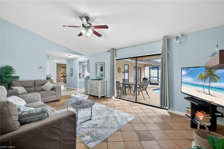 Living area featuring ceiling fan and lofted ceiling