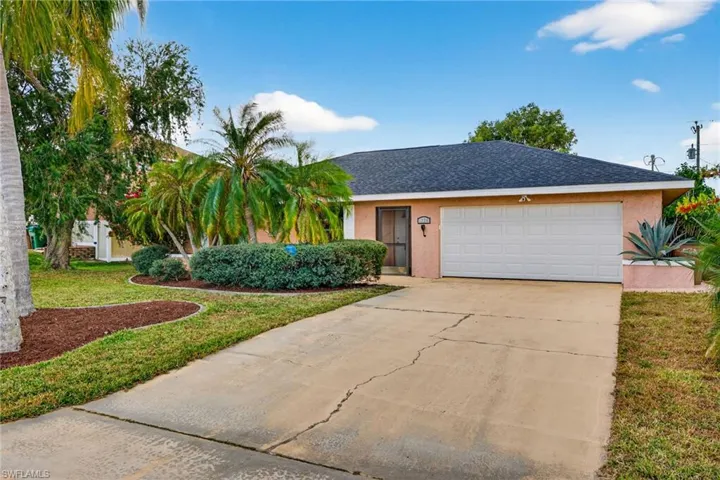 View of front of home featuring driveway, stucco siding, a shingled roof, a front yard, and a garage