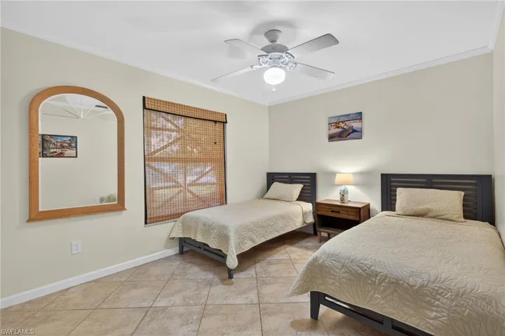 Bedroom featuring crown molding, ceiling fan, and light tile patterned flooring