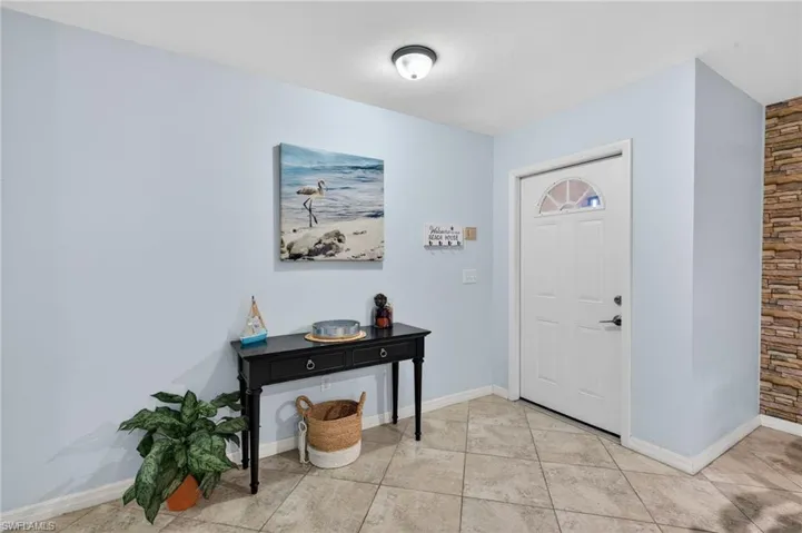 Entryway featuring baseboards and light tile patterned floors