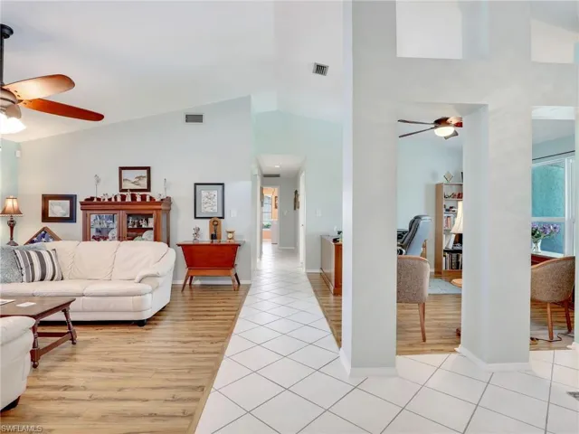Living room featuring high vaulted ceiling and ceiling fan