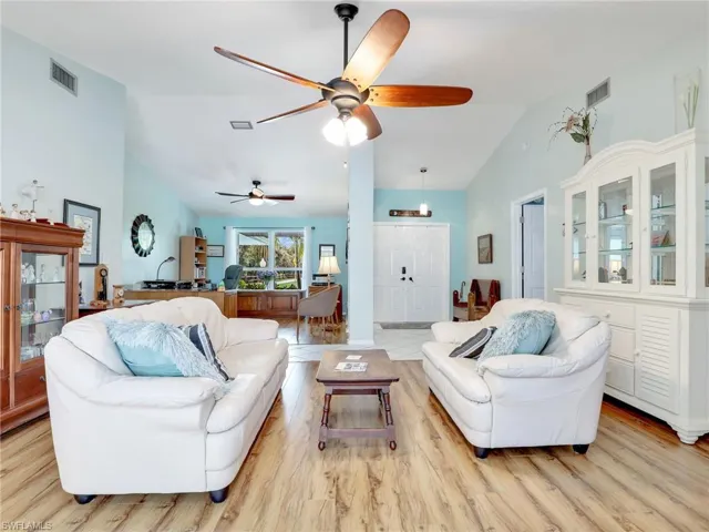 Living room with high vaulted ceiling, and ceiling fan