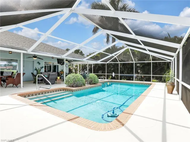 View of swimming pool featuring a screen enclosure, and a patio area