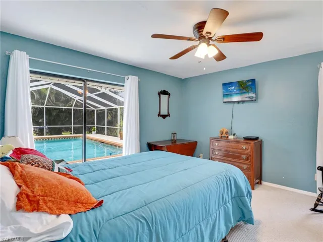 Bedroom featuring ceiling fan, carpet ,and access to pool